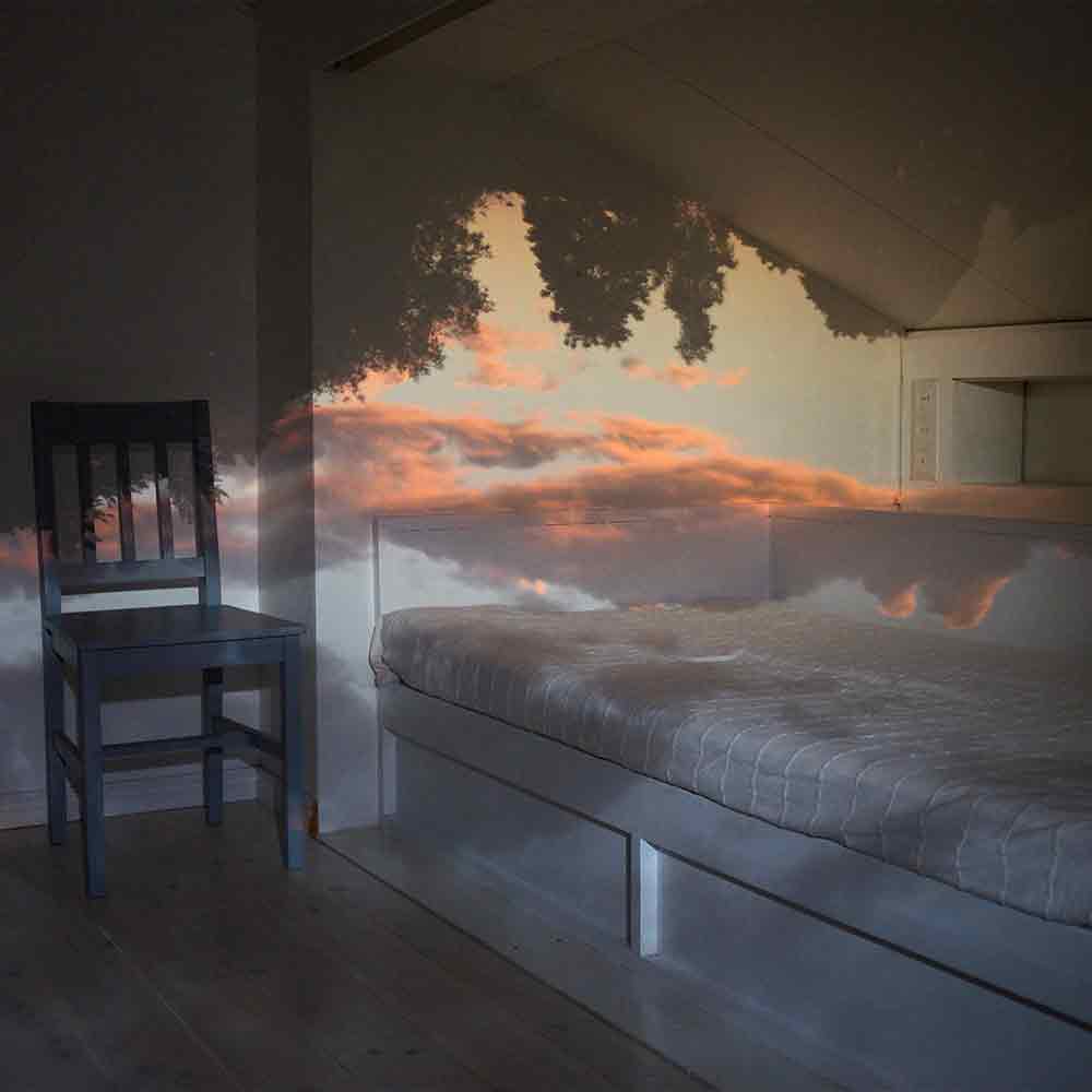 Bonfoton Camera Obscura Room image from Porvoo Finland. Sunset clouds within a room with a chair and bed. 